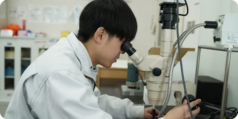 研究設備で観察作業をする研究開発職社員